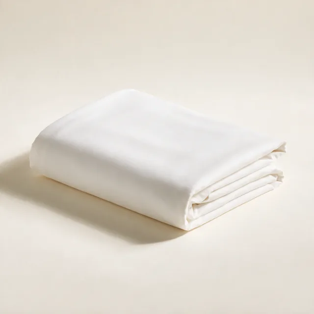 A folded cotton percale sheet set in soft white