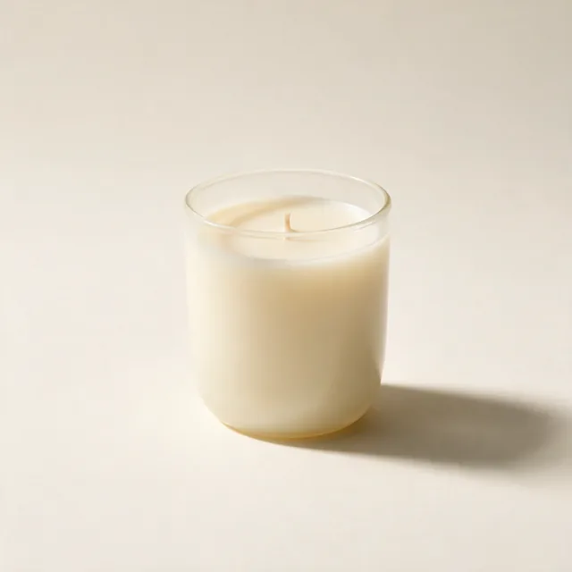 A soy candle in a plain matte glass, unlit