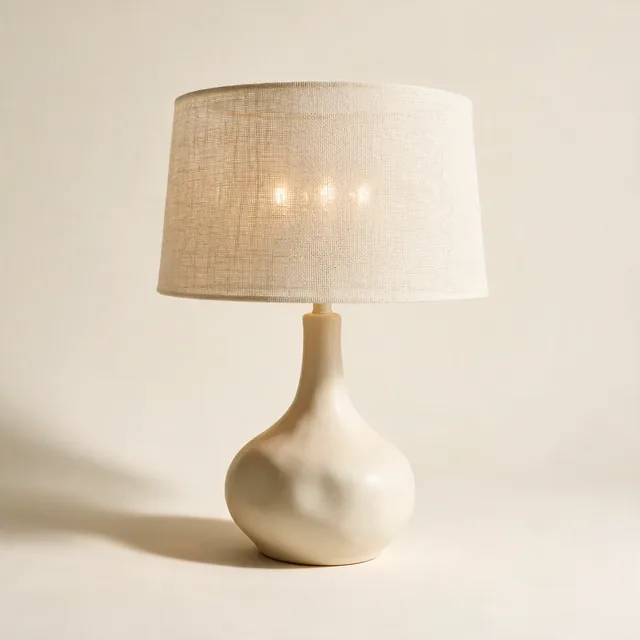 A ceramic table lamp with a linen drum shade