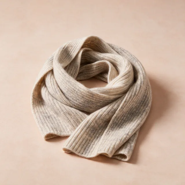 A cashmere scarf folded into a soft coil