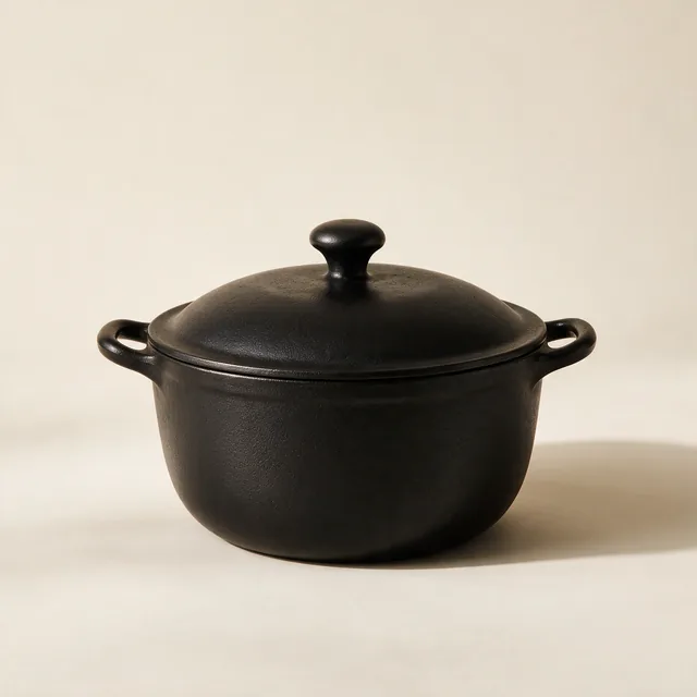 A matte black cast iron dutch oven with its lid on
