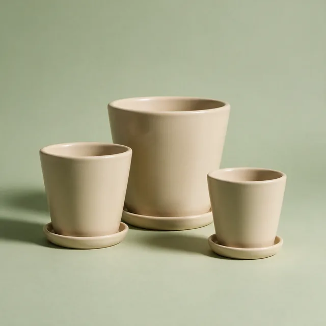 Three plain ceramic plant pots with drainage saucers