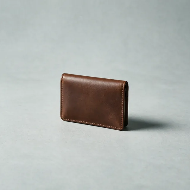A slim dark tan leather wallet, closed