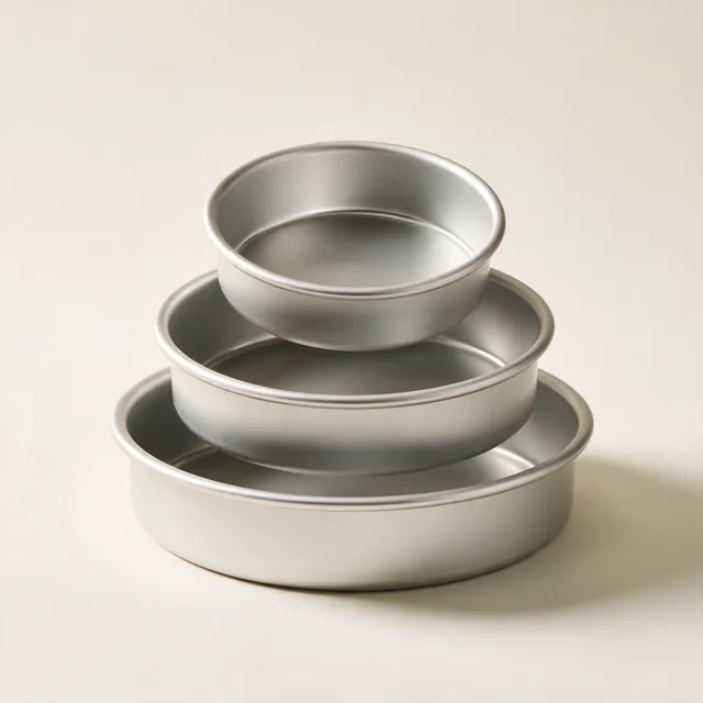 Three anodized aluminum cake pans stacked at an offset