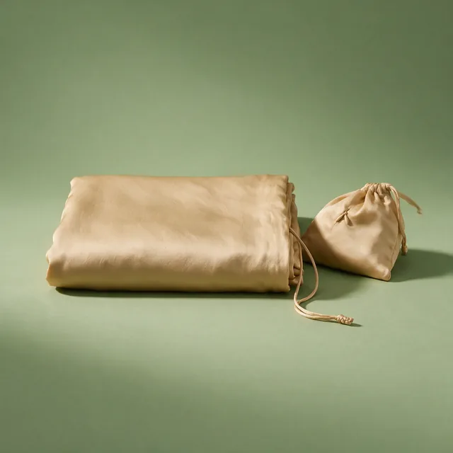 A folded silk sleeping bag liner with its stuff sack