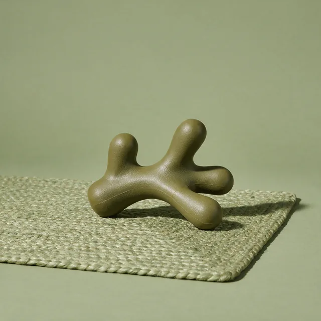 A rubber dog chew toy on a woven mat
