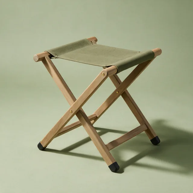 A folding garden stool with a canvas seat