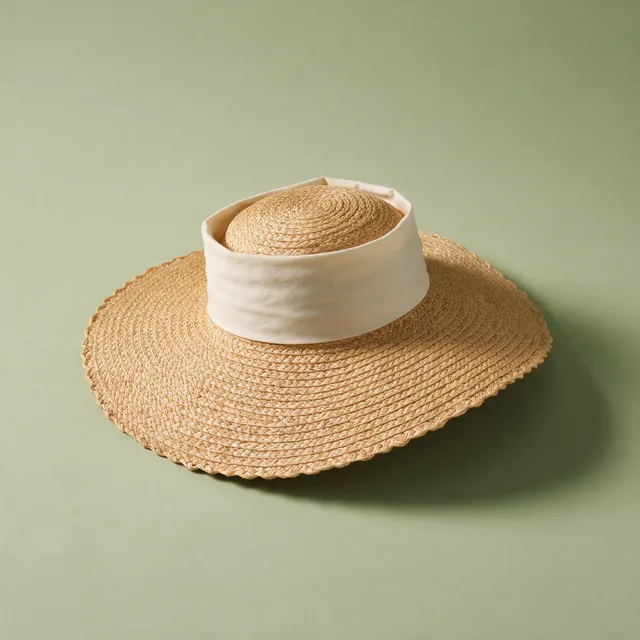 A wide-brimmed straw garden hat resting crown down