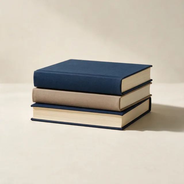 A stack of three hardcover books with plain cloth bindings
