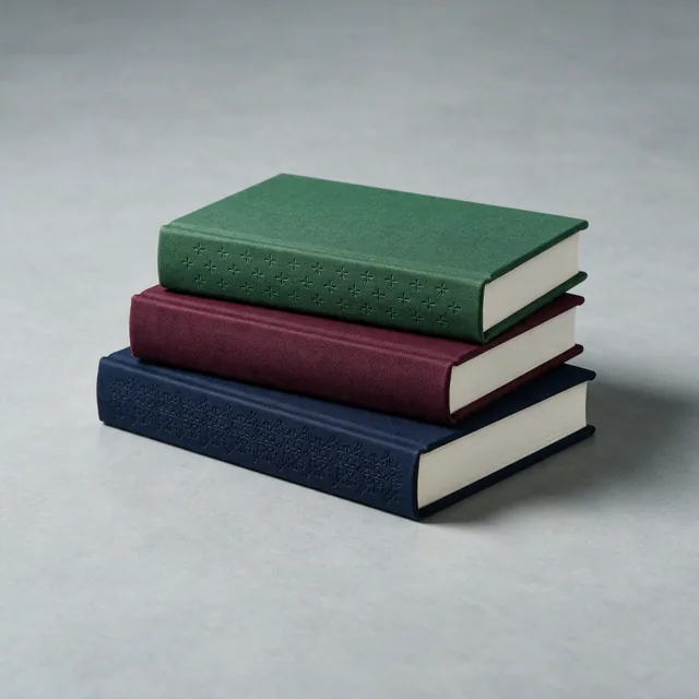 Three clothbound hardcover books stacked, spines blank
