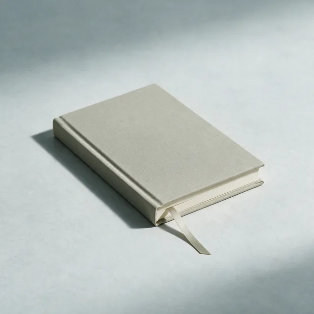 A closed hardcover notebook in stone cloth with a ribbon marker