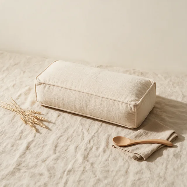A rectangular yoga bolster in oatmeal cotton