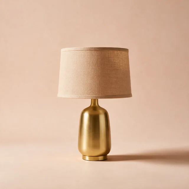 A table lamp with a linen shade and a brass base